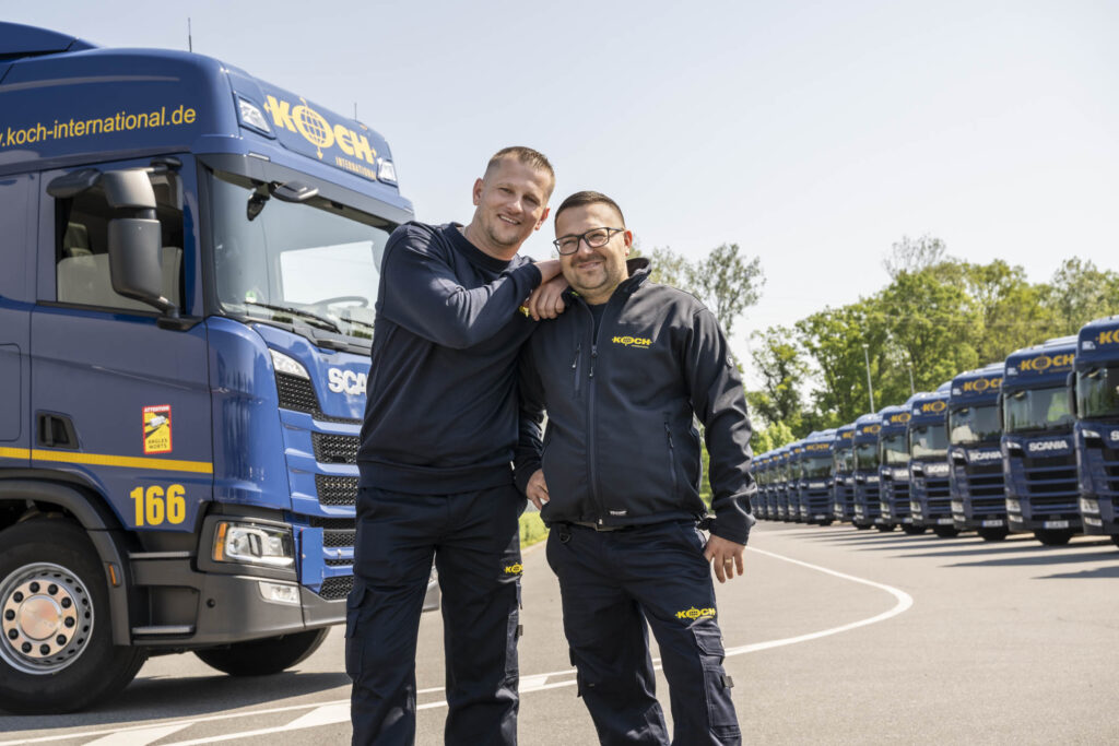 Zwei LKW Fahrer mit LKW im Hintergrund